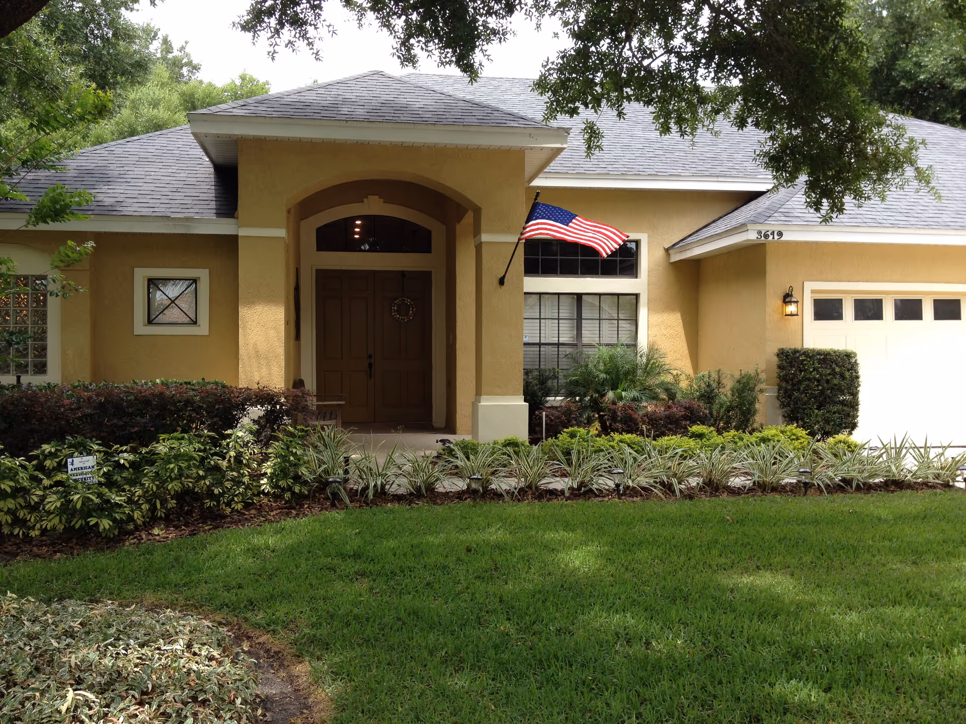 Front view of Bridgeport Senior Living entry with flag and landscaping