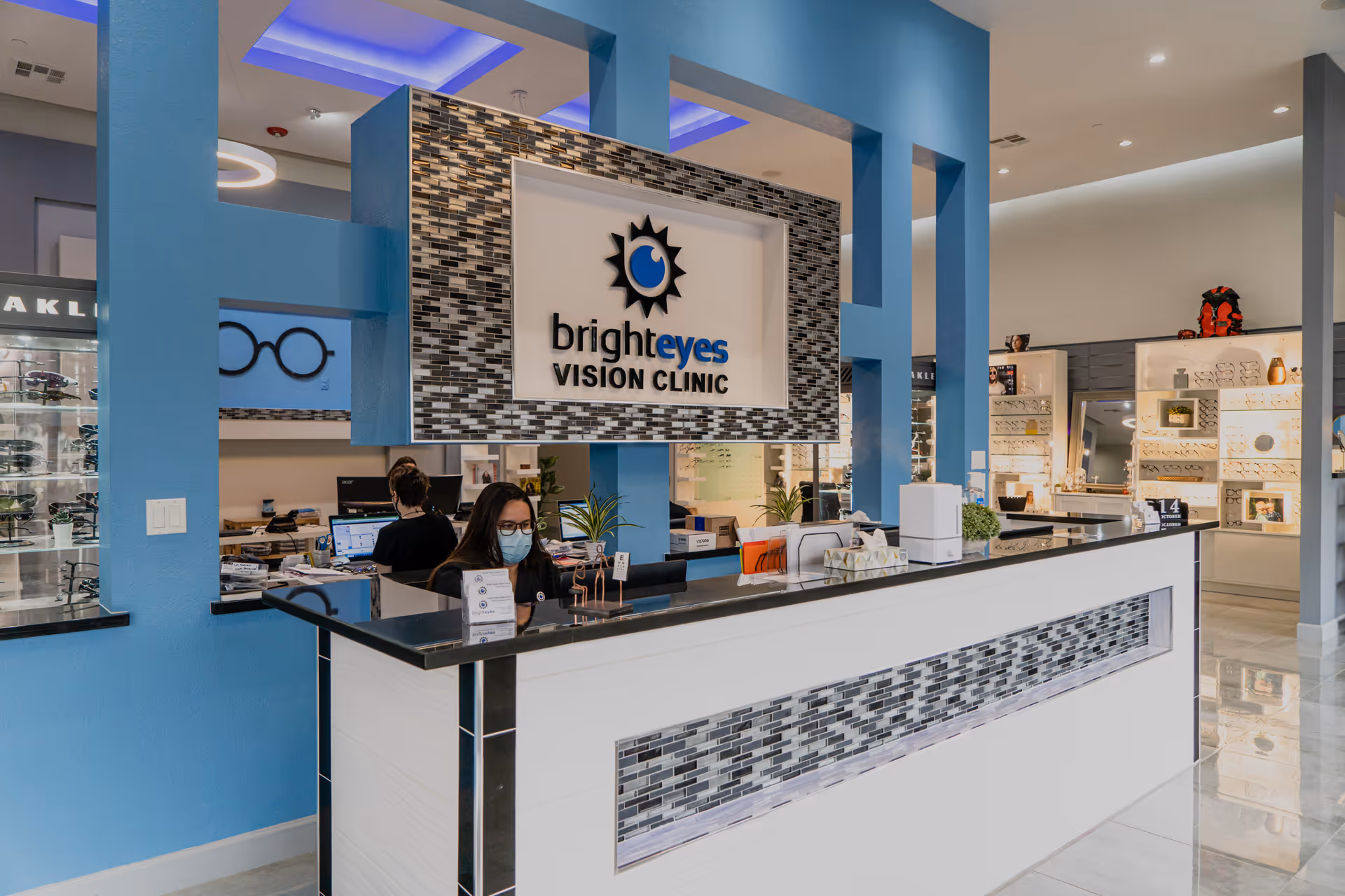 Bright reception area with blue accents and a Bright Eyes Vision Clinic sign.
