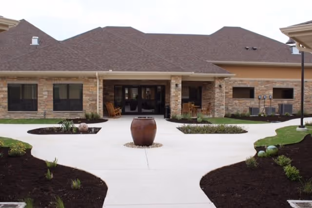 Front exterior of Falcon Ridge Rehabilitation with entryway, stone facade, and manicured walkways.