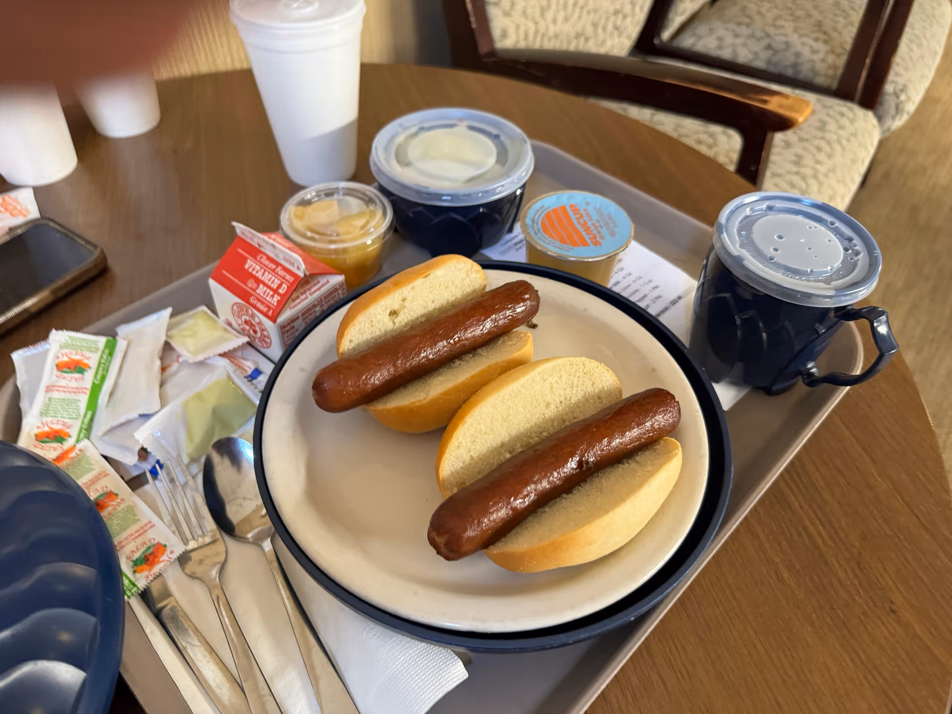 In West Caldwell Care Center dining area, two hot dogs on buns on a serving tray.