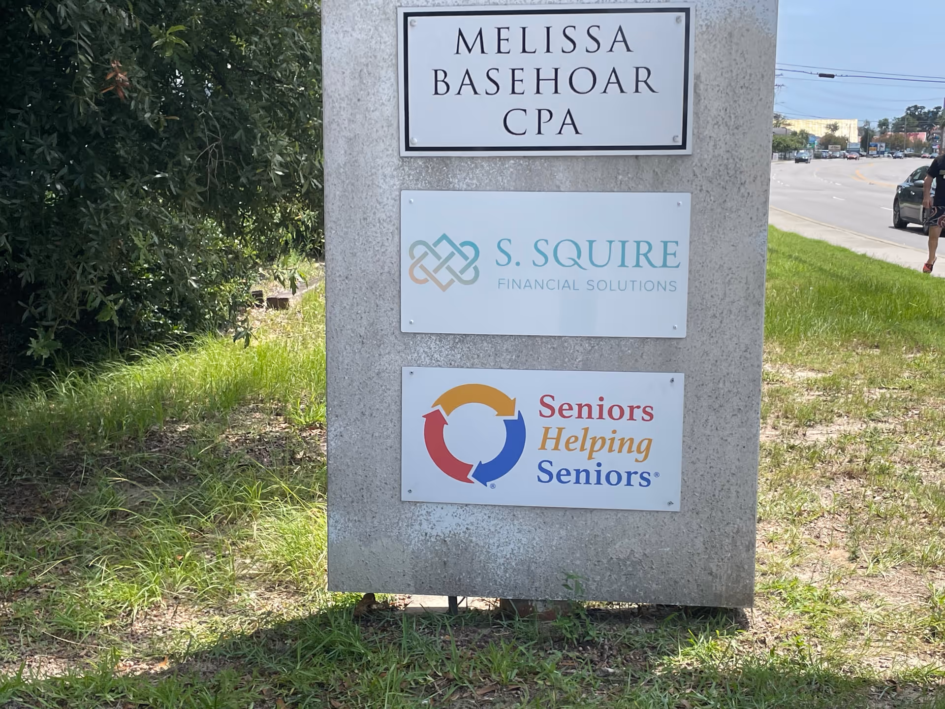 Stone sign pillar with three plaques for Melissa Basehoar CPA, S. Squire, and Seniors Helping Seniors.