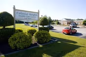 Exterior view of Colonial Heights Health Care Center with sign and parked cars.