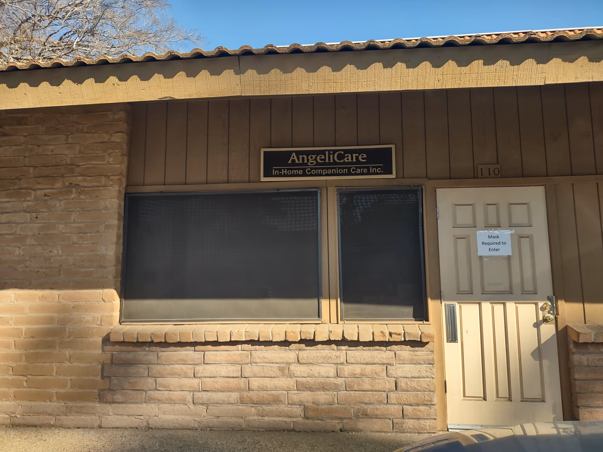 Front exterior of AngelCare In-Home Companion Care building with sign and entry door.