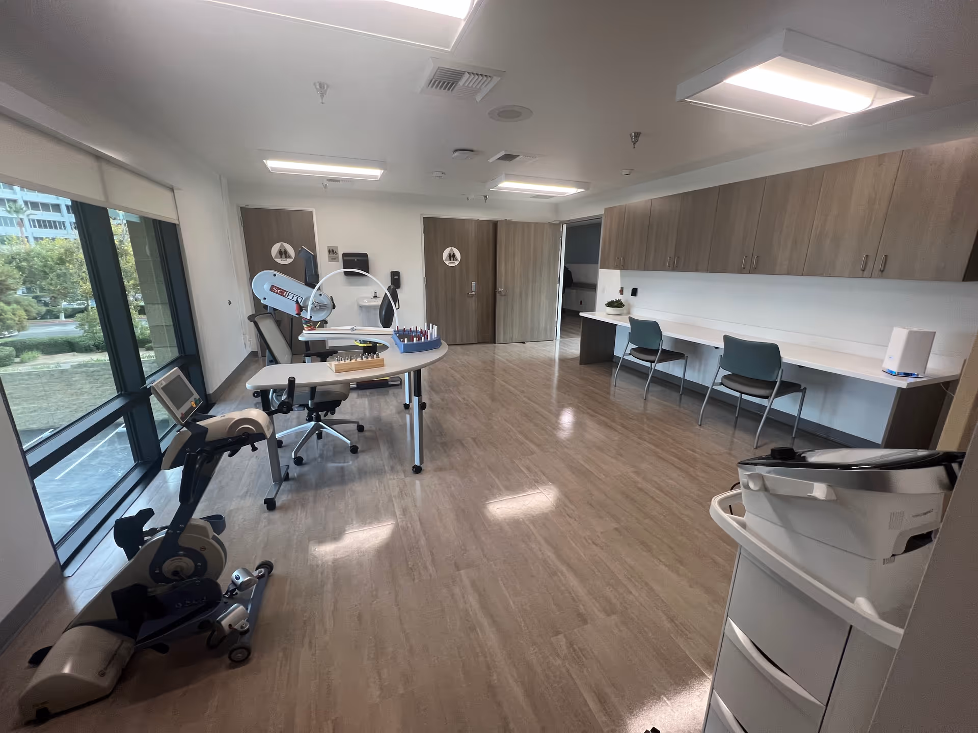 Bright, modern interior of a therapy room with exercise equipment and cabinets.