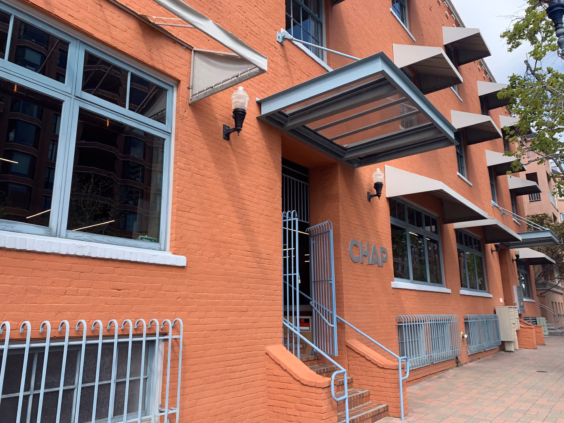 Brick CHAP building exterior with blue railings and glass entrance.