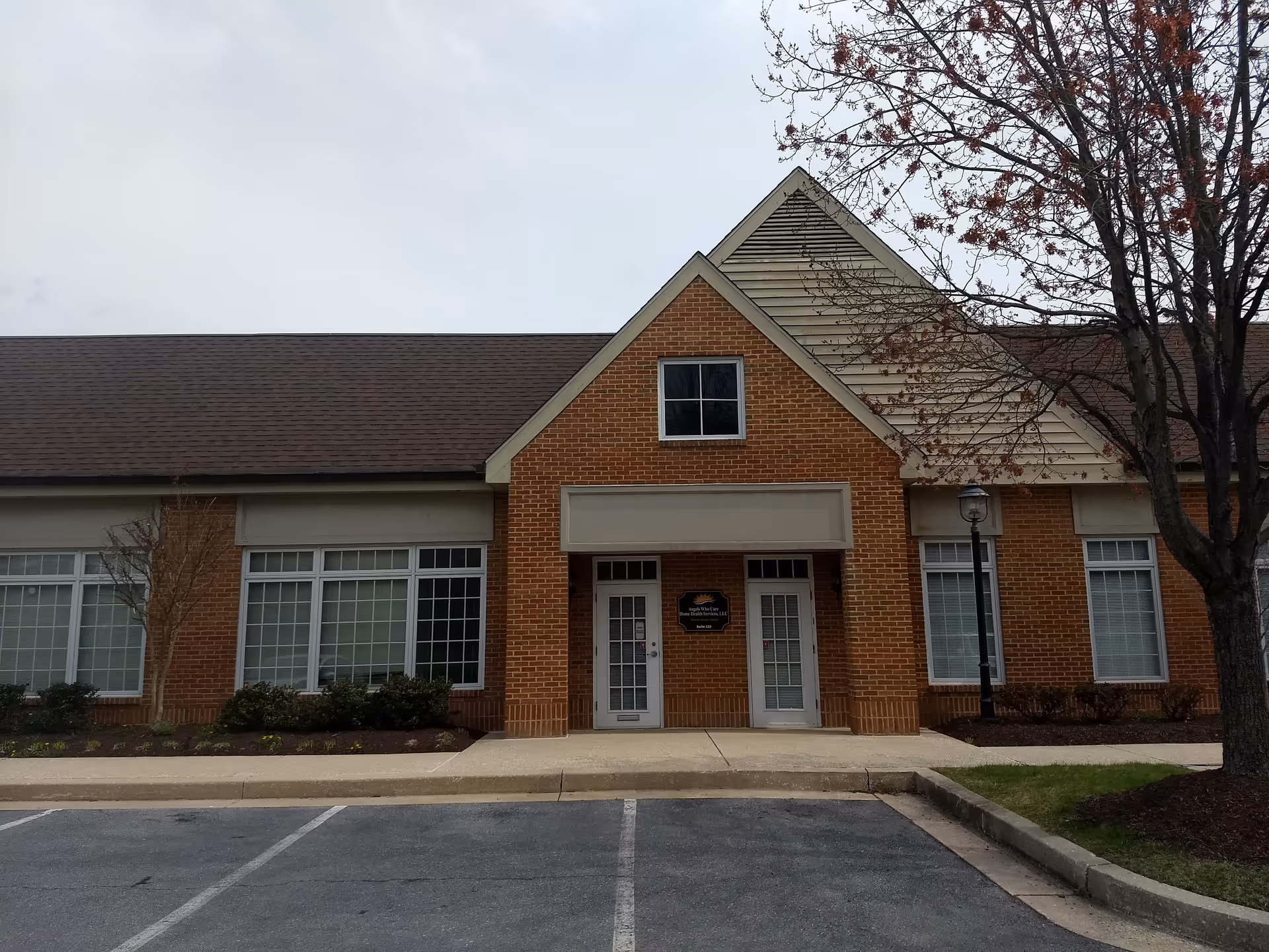 Brick building exterior with peaked roof, large windows, and front entrance.