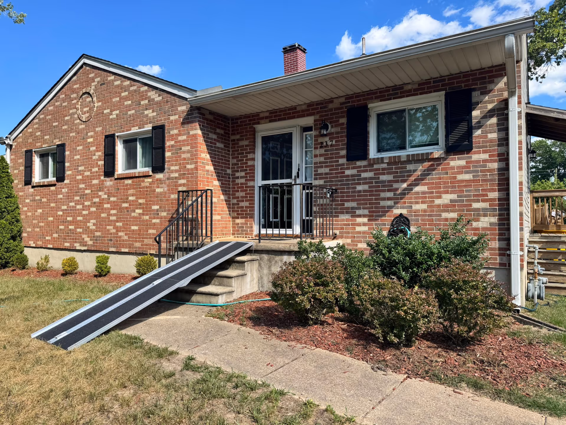 Front view of a brick senior living facility with a wheelchair ramp at the entrance.