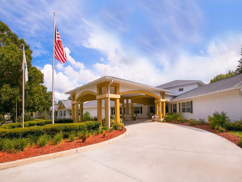 Exterior view of a Heron East senior living facility entrance with a covered porte-cochere.