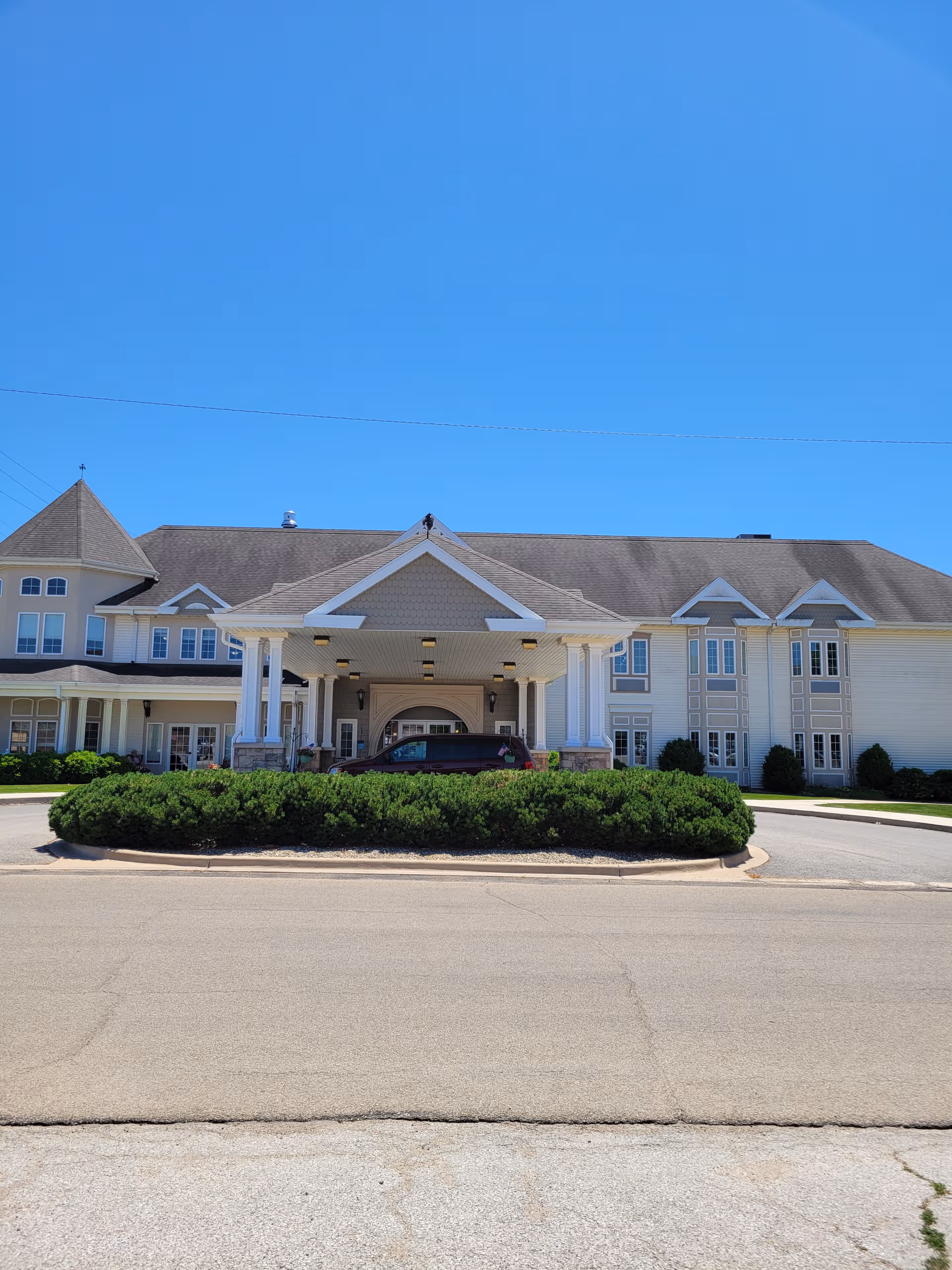 Front view of Heritage Woods of Canton with entrance canopy and landscaped roundabout.