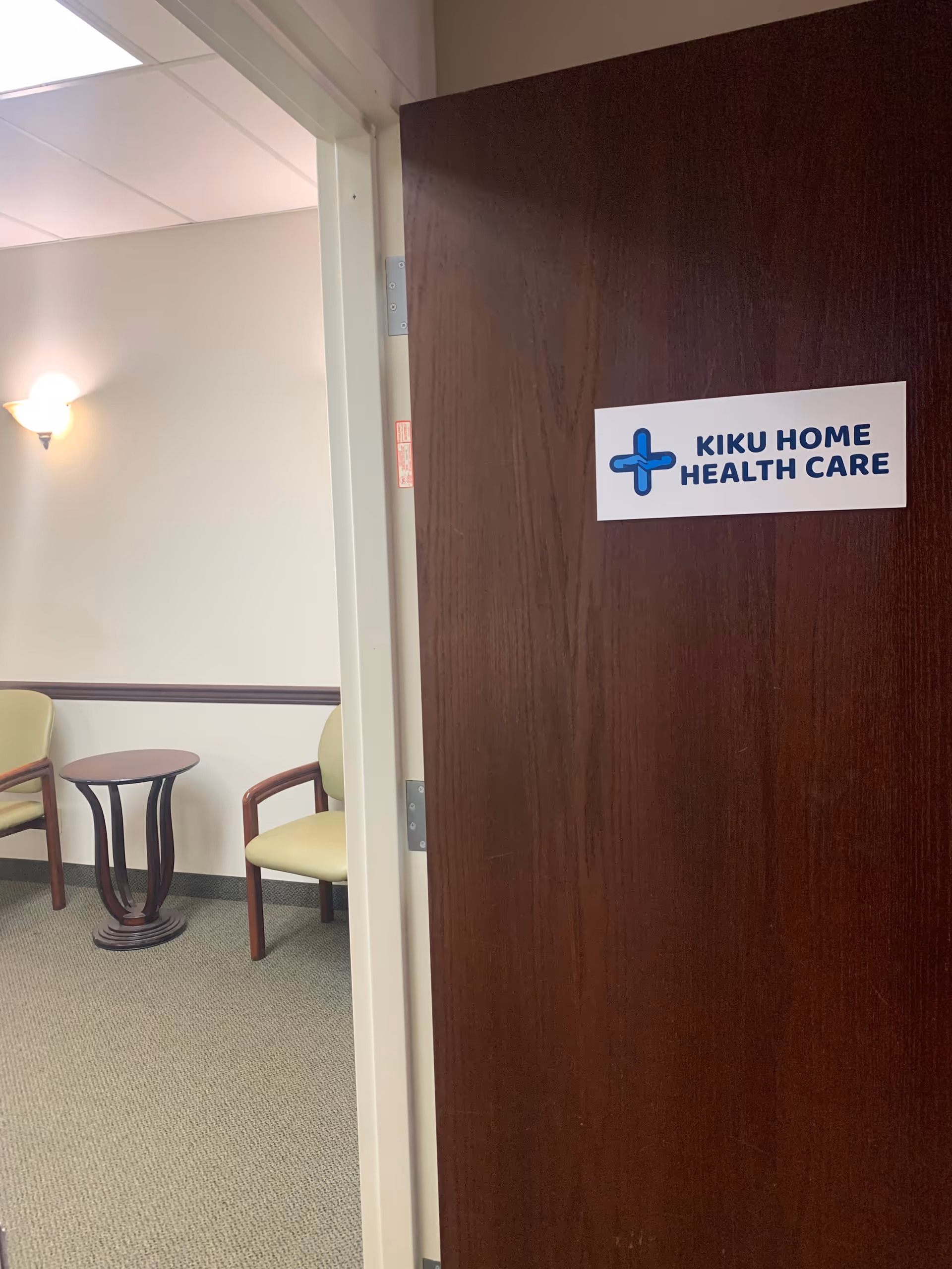 Open doorway to a waiting area with two chairs and a round table.