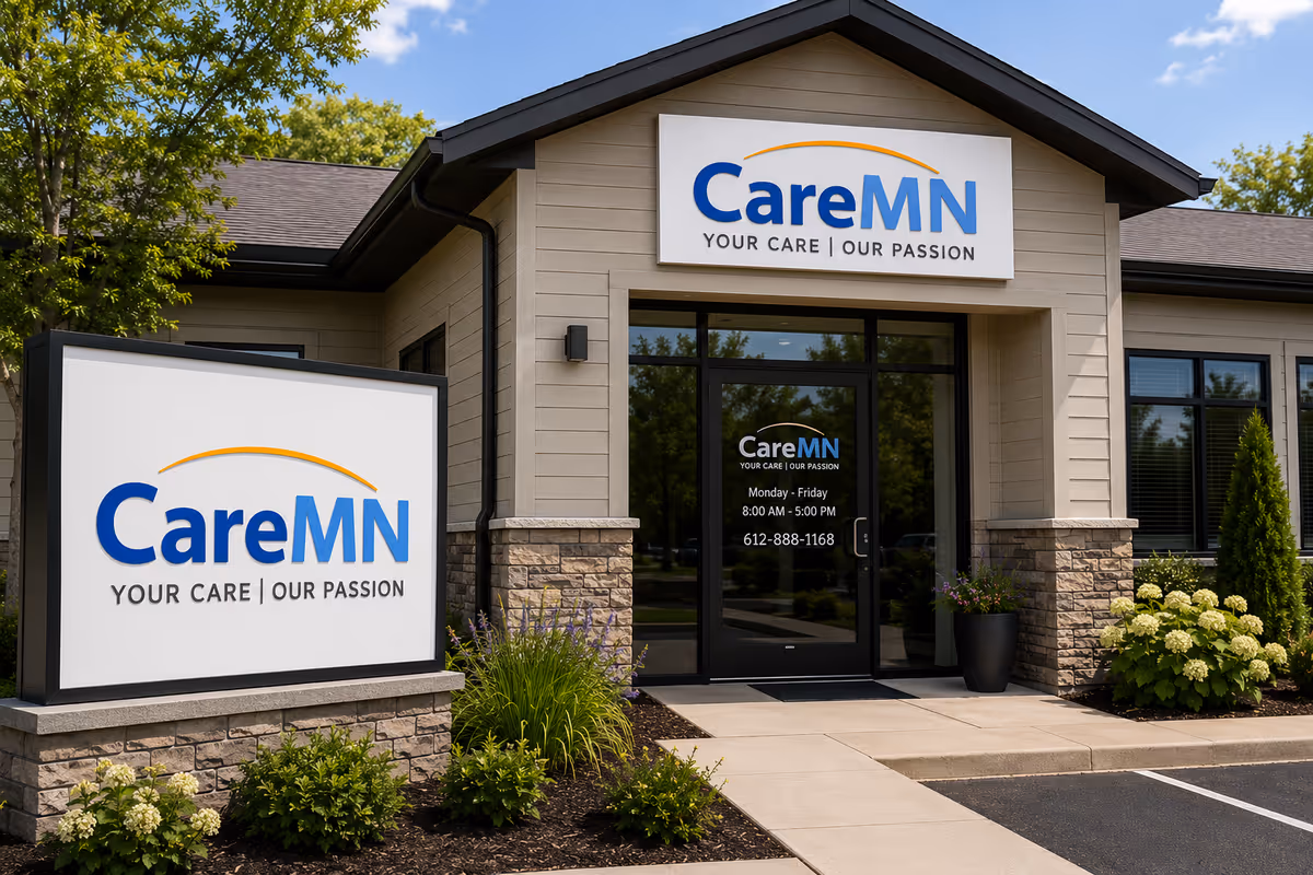Exterior view of a CareMN building with prominent sign, glass doors, and landscaped entrance.