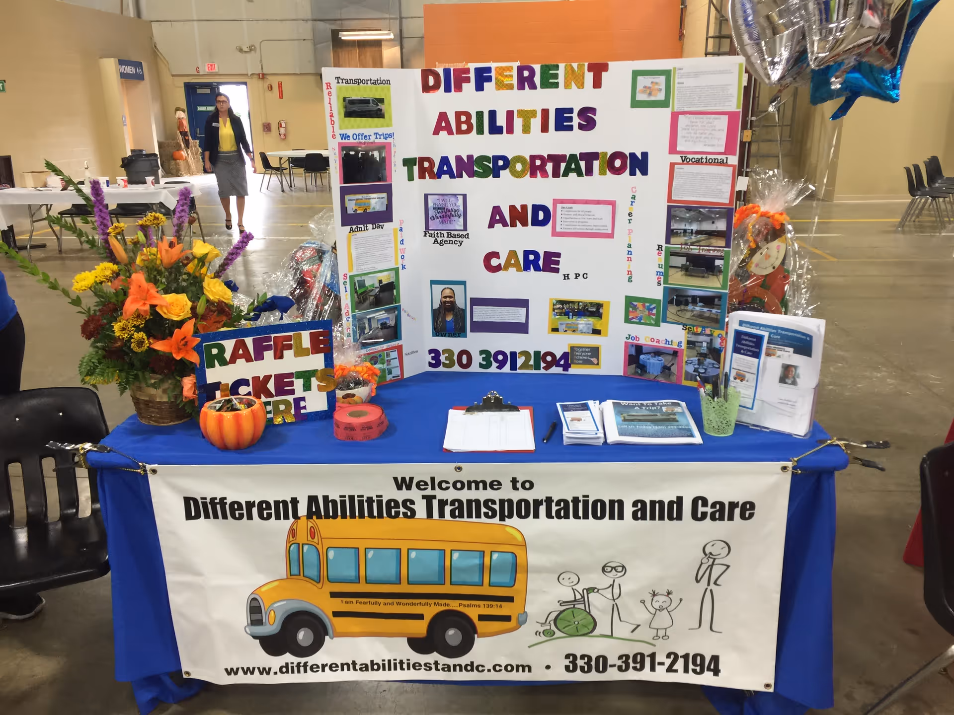 Colorful information booth with posters and a bus illustration at an indoor event.