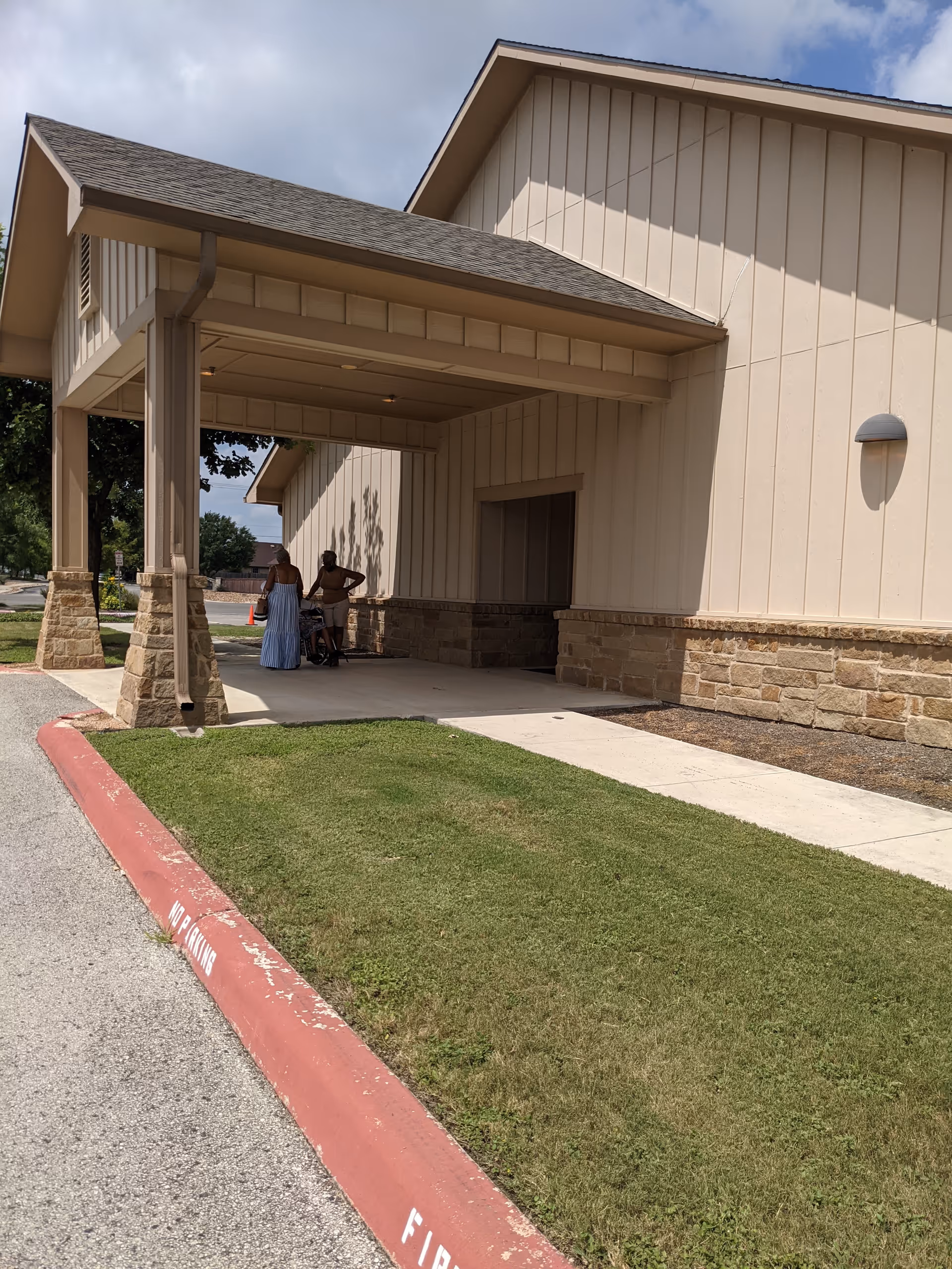 Exterior view of Lakeside Nursing and Rehabilitation Center entrance with two people standing nearby.