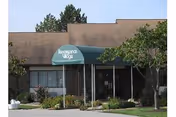 Front exterior view of Majestic Care of West Allen with green awning over entrance.