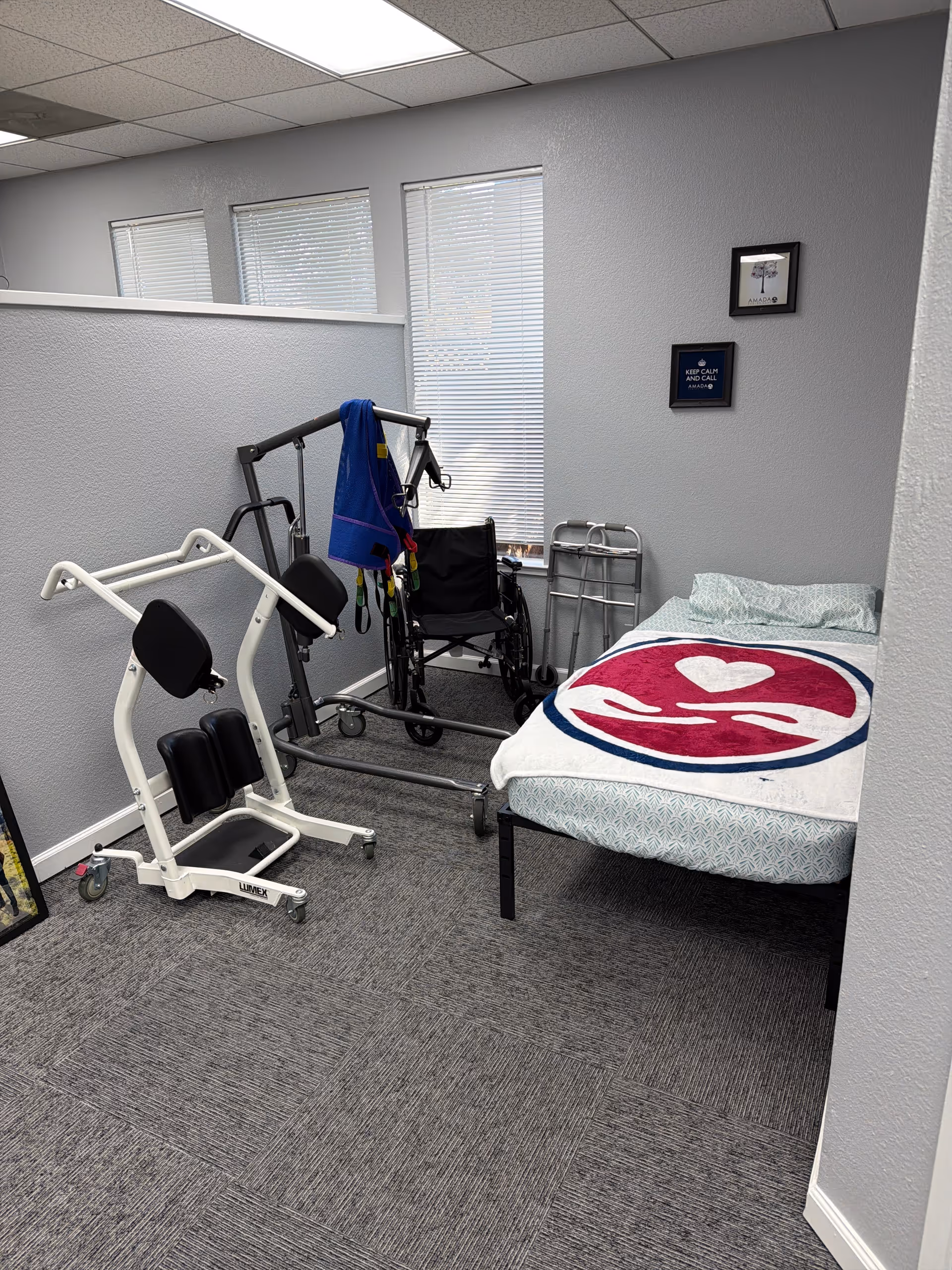 Small interior rehab room with a bed, wheelchair, walker, and exercise equipment.