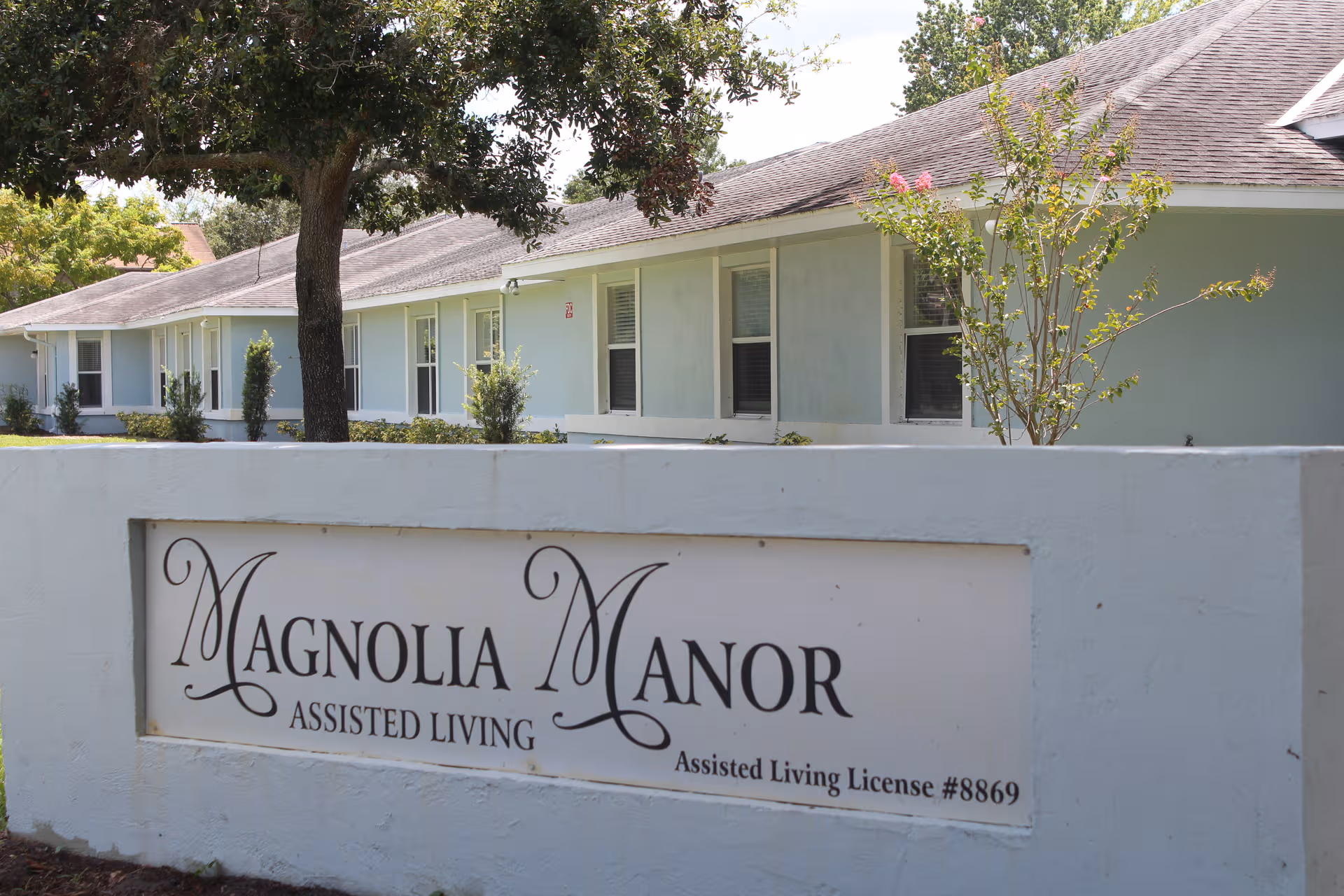 Exterior view of Magnolia Manor Assisted Living with its sign.