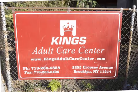 Red Kings Adult Care Center sign on a chain-link fence with address and contact details.