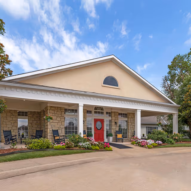 Exterior view of Country Gardens Assisted Living front porch with chairs and blooming flowers