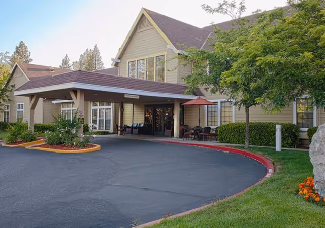 Exterior view of Hilltop Commons Senior Living with a covered entrance.