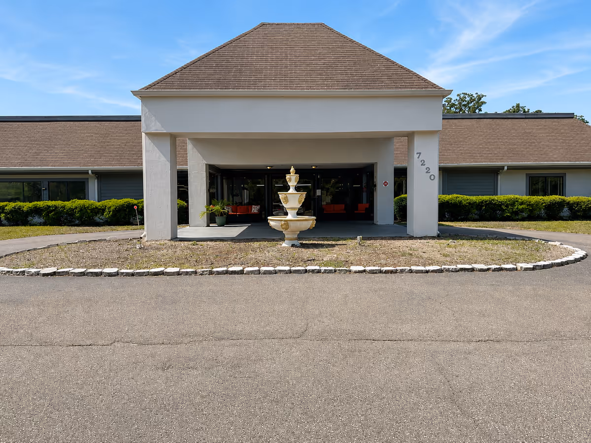 Front entrance of Oakview Terrace Assisted Living with a circular driveway and fountain.