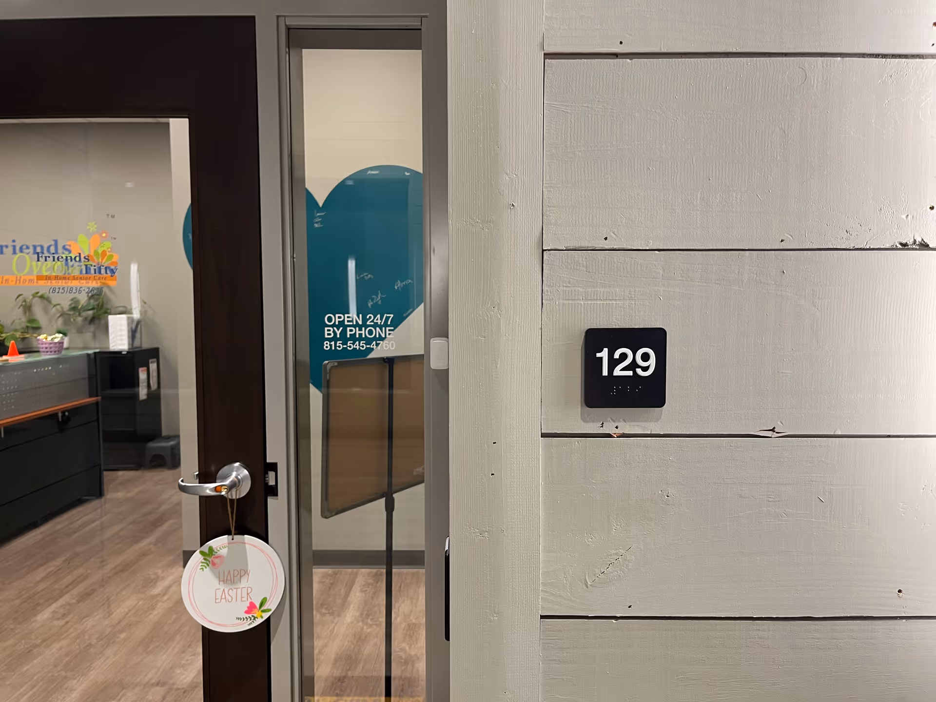 Exterior entrance to a senior care facility with door, window, and 129 plaque.