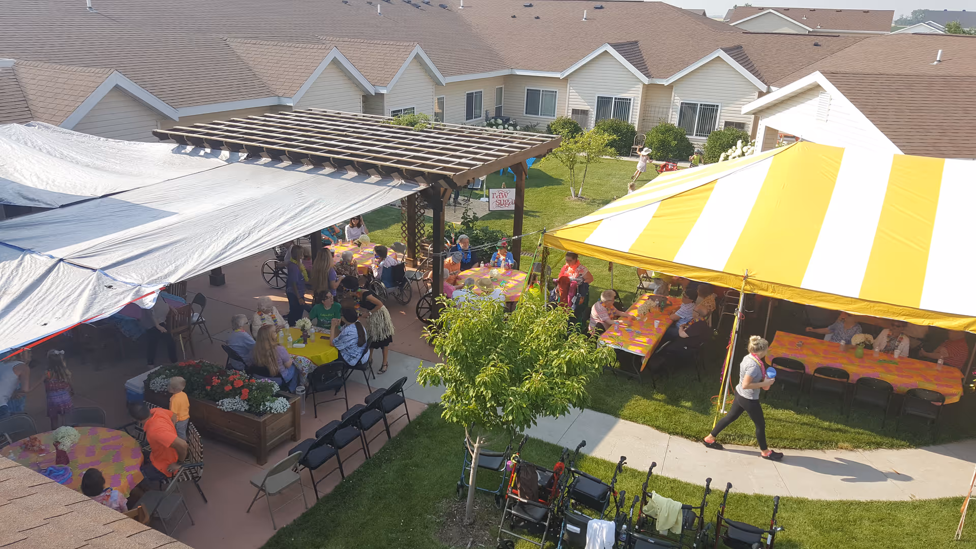 Outdoor courtyard at Serenity Living Center with tents, tables, and residents dining together.