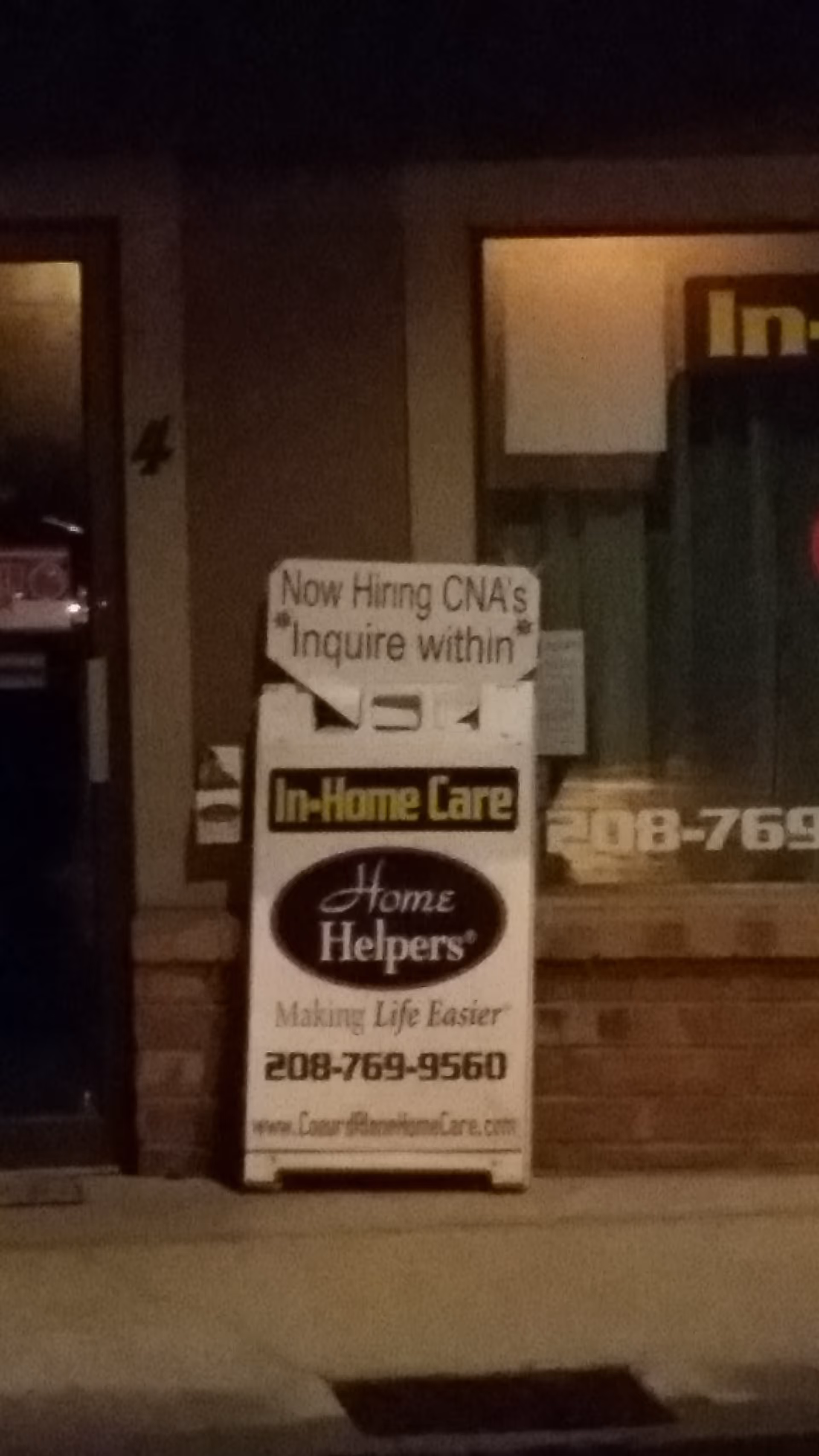 Night exterior view of a building with a Home Helpers In-Home Care sign.