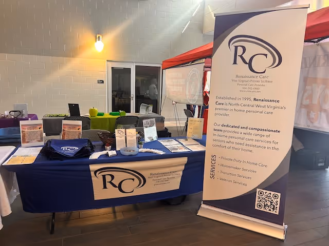 Indoor vendor booth for Renaissance Care with banner, brochures, and table setup.
