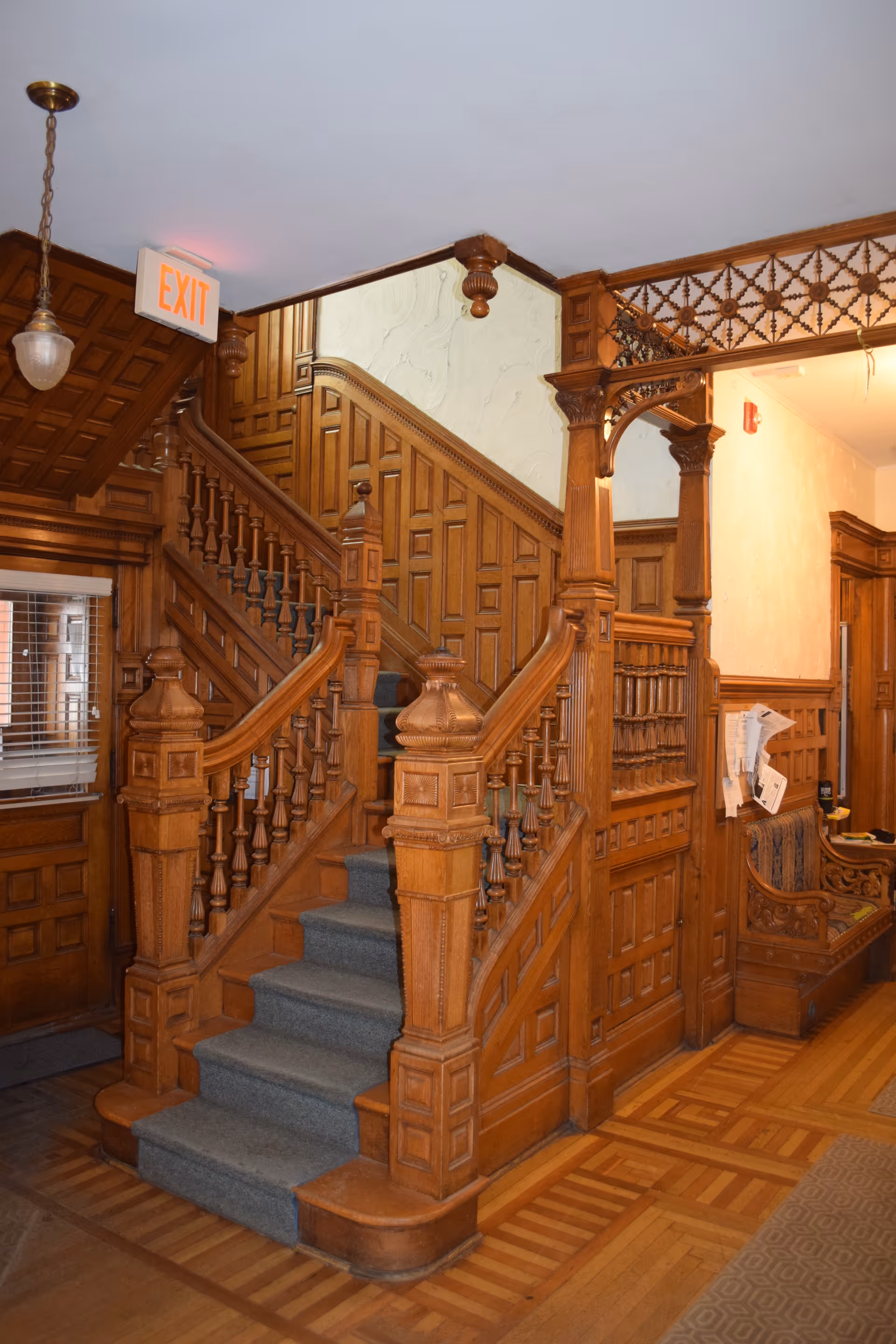 Ornate wooden staircase with carved balustrades inside a historic interior.