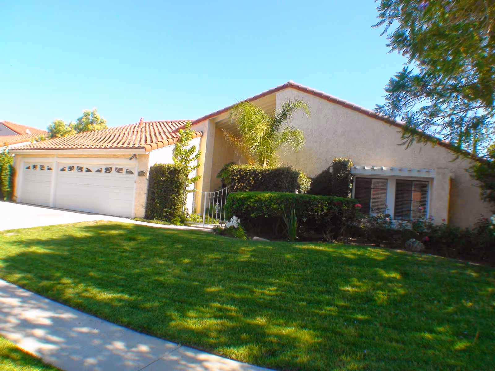Front view of a single-story house with a garage and green lawn