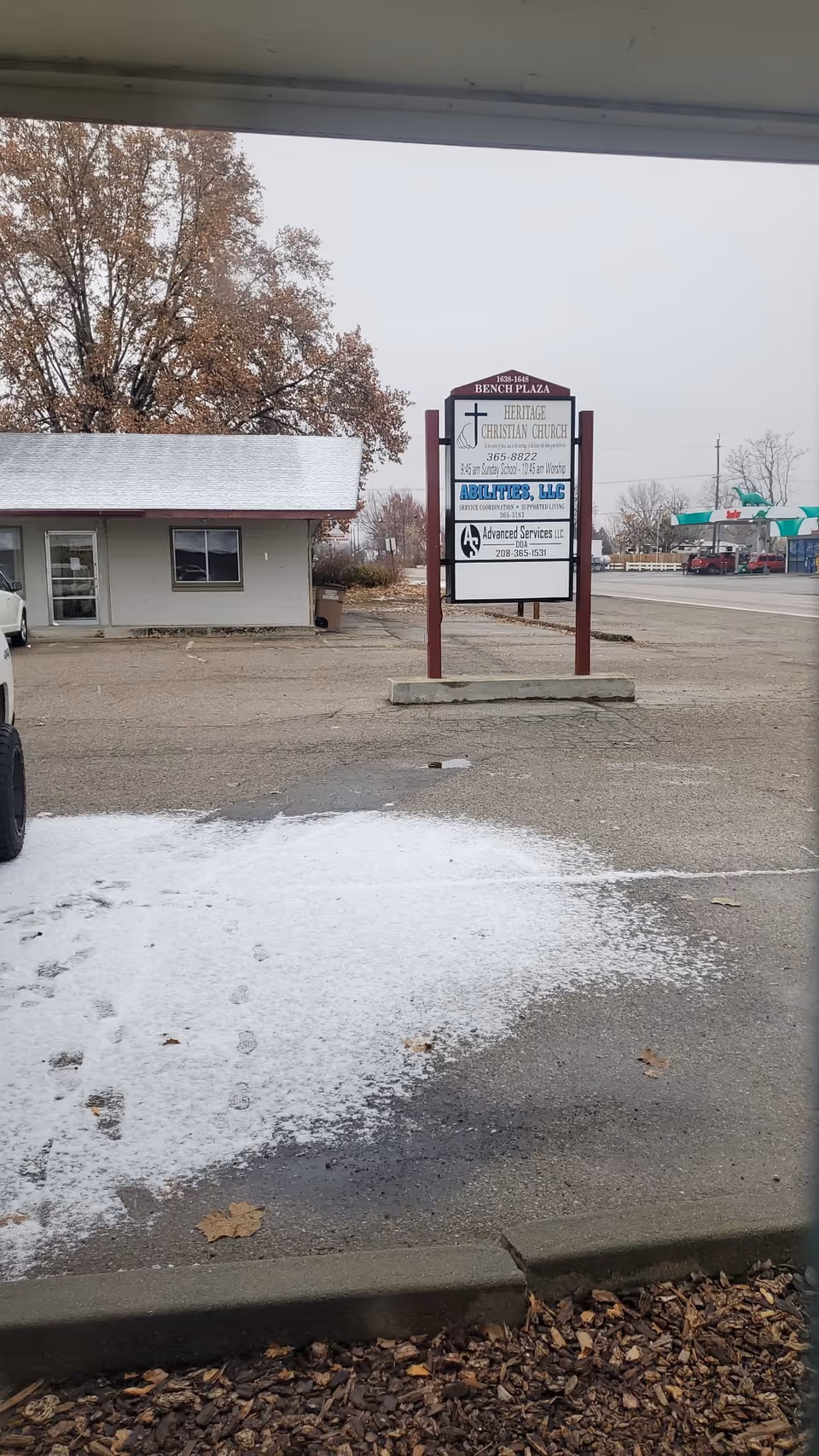 Outdoor street view with a sign for Abilities, LLC near a small building and snow.