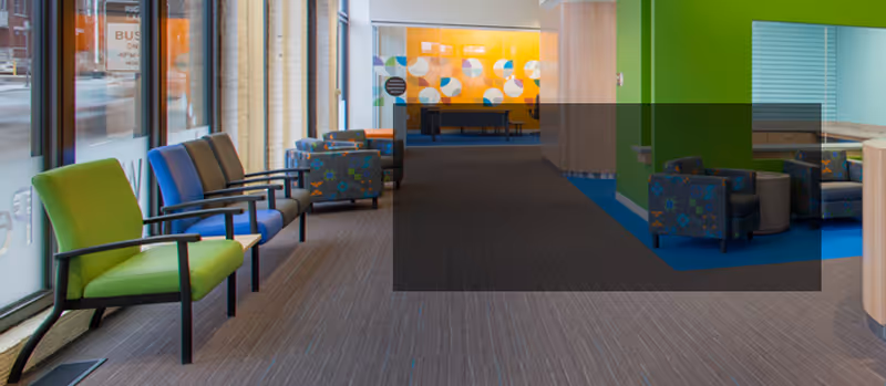 Interior waiting area in a senior living facility with bright chairs.
