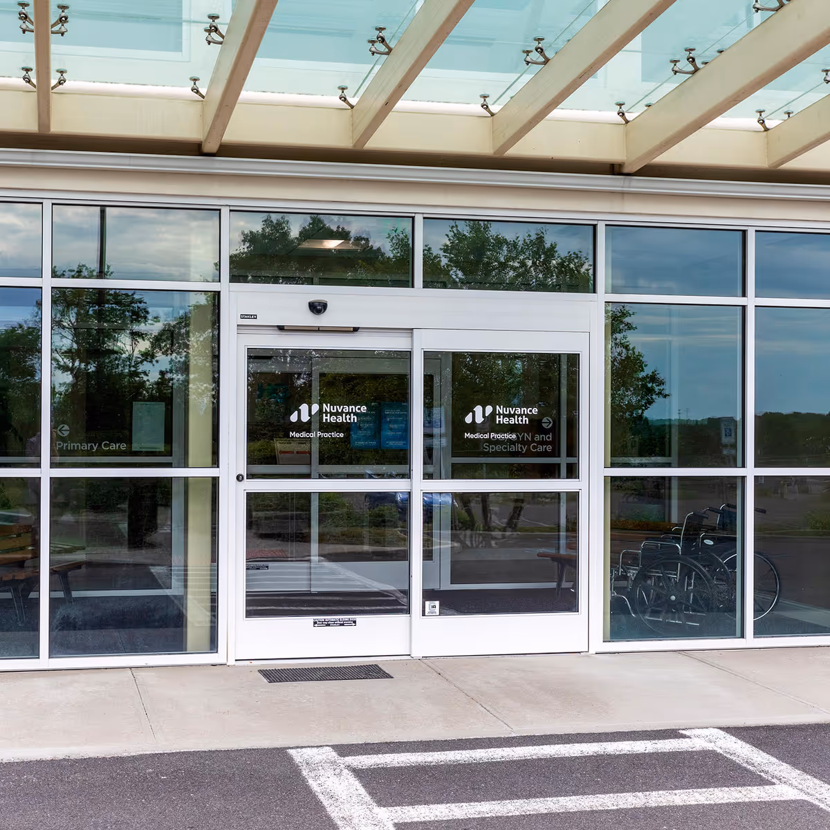 Glass entrance of Nuvance Health Medical Practice with a wheelchair inside.