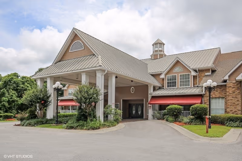 Exterior view of The Waterford at Carpenter's Creek entrance with porte-cochère and red awnings.