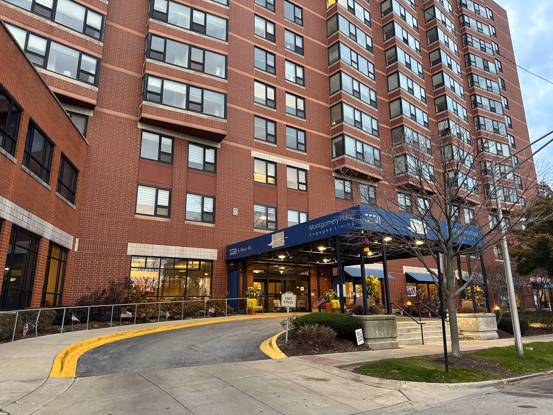 Front entrance of Montgomery Place Retirement Community, a multi-story red-brick building with a covered drop-off canopy and curved driveway.