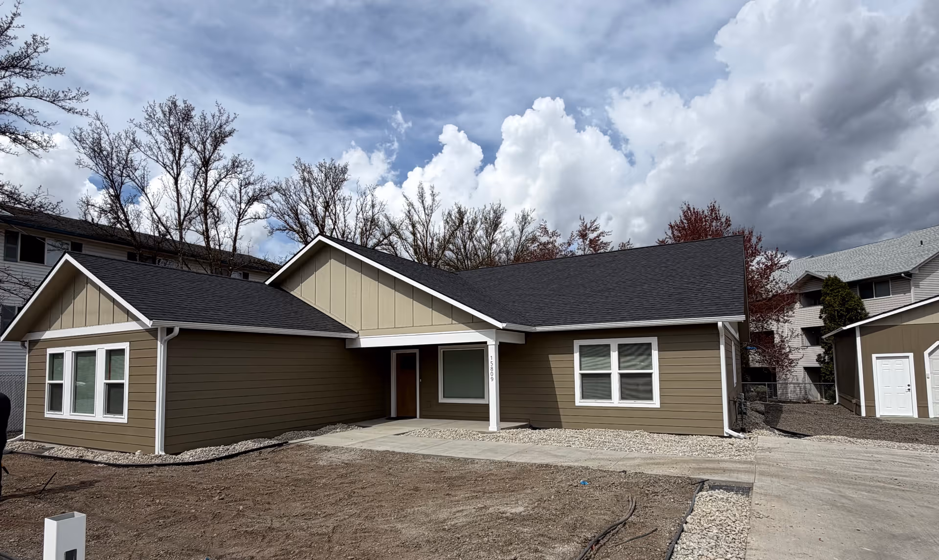 New single-story building with a covered entrance and dark sloped roof, front view