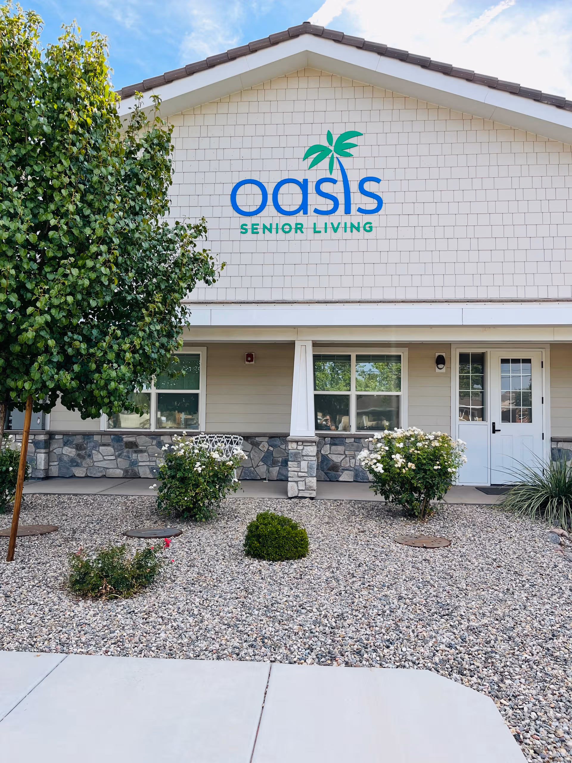 Front view of Oasis Senior Living building with stone trim and landscaping.