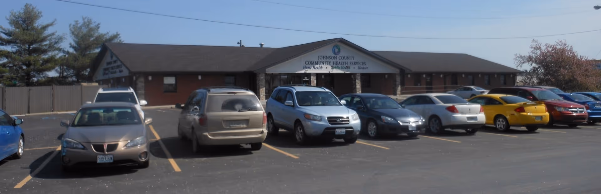 Front view of Johnson County Community Health Services building with a row of parked cars.