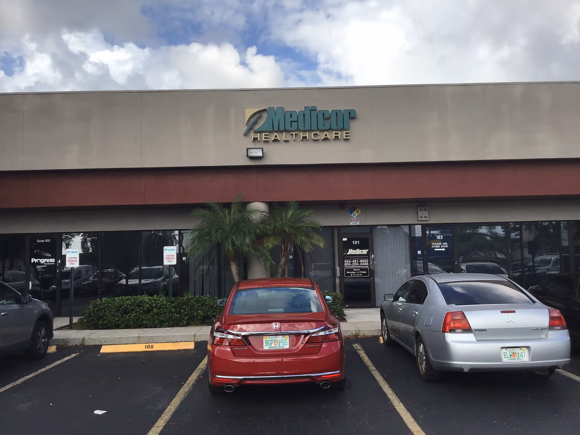 Front exterior of Medicor Healthcare building with parked cars in front