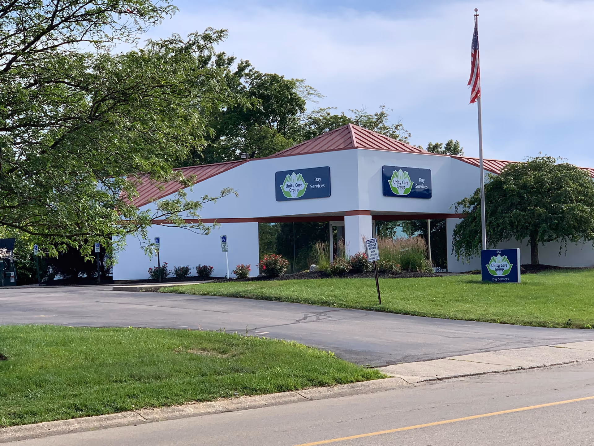 Exterior view of a Unity Care Group LLC facility with signs and landscaping.