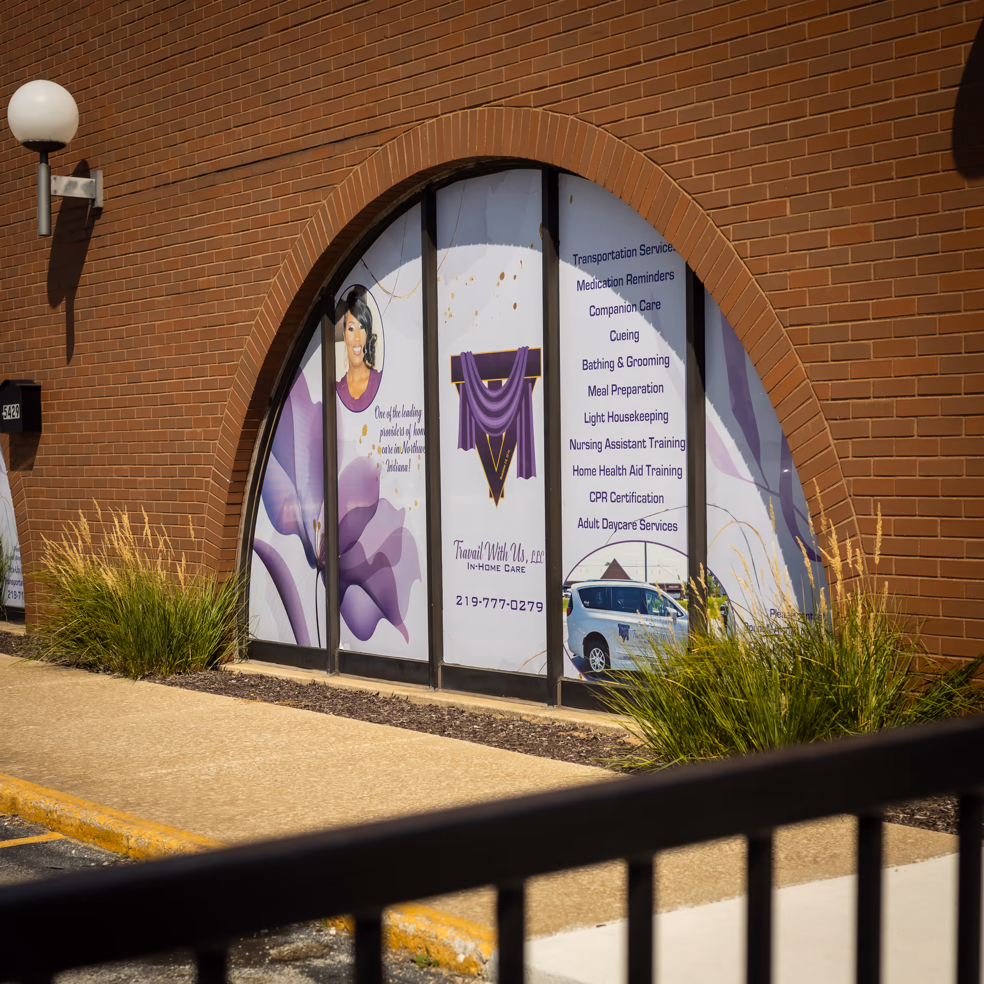 Brick building front with arched doorway and banners advertising Travail With Us.