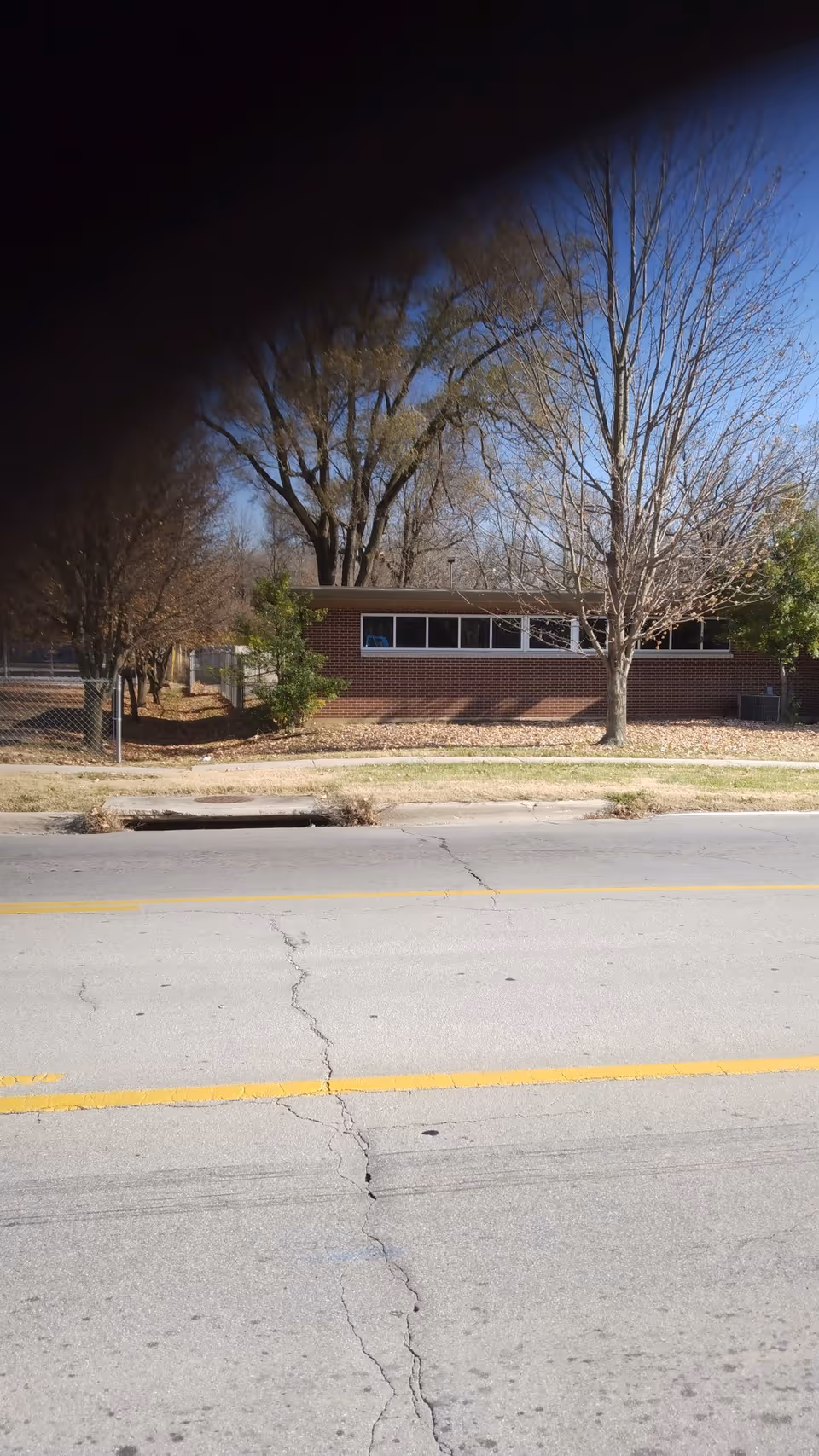 Exterior view of Westside Public Health Center across the street; brick building behind a fence.