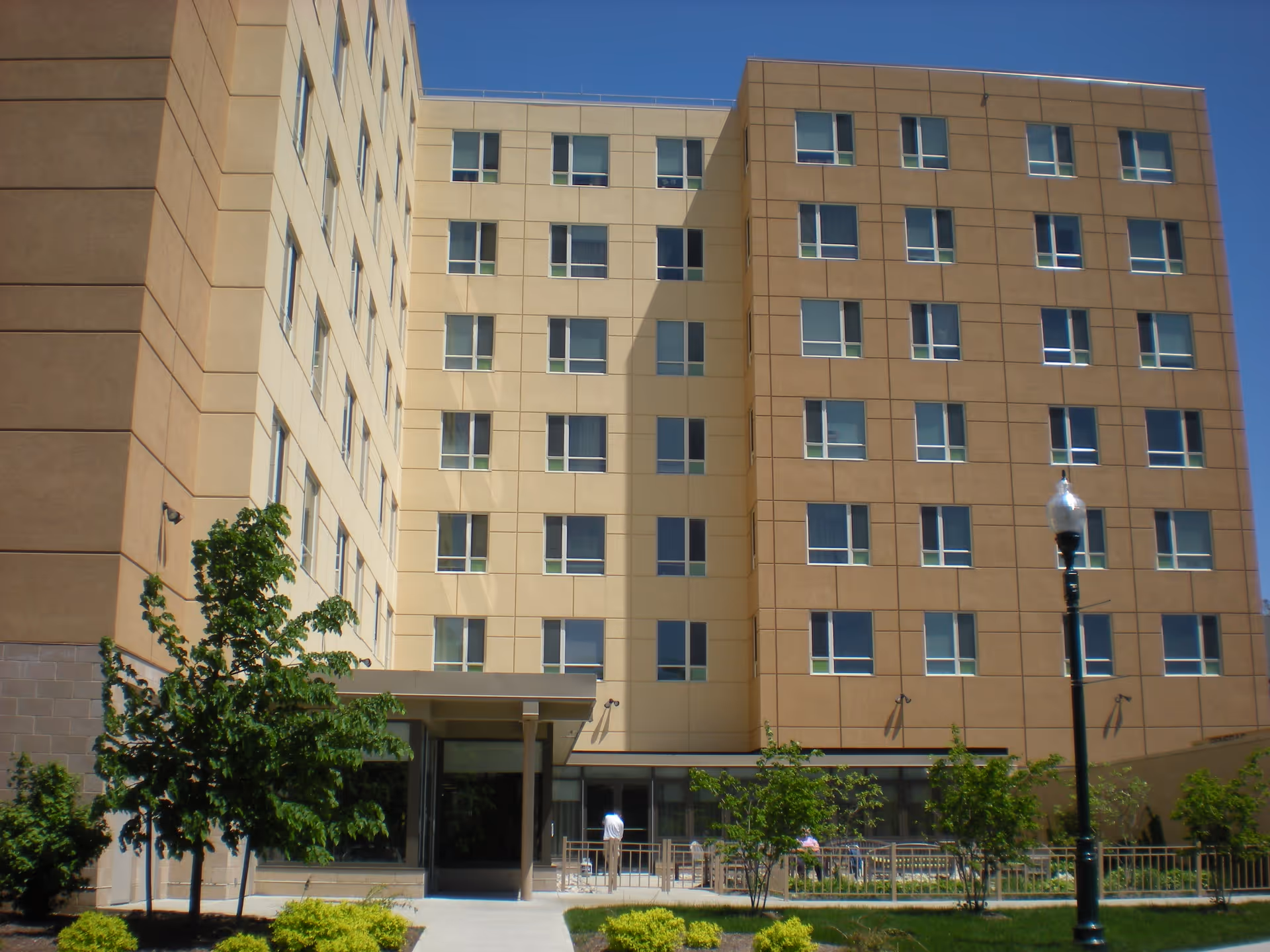 Garito Manor At Union Square: front exterior of a multi-story senior living building with outdoor seating.