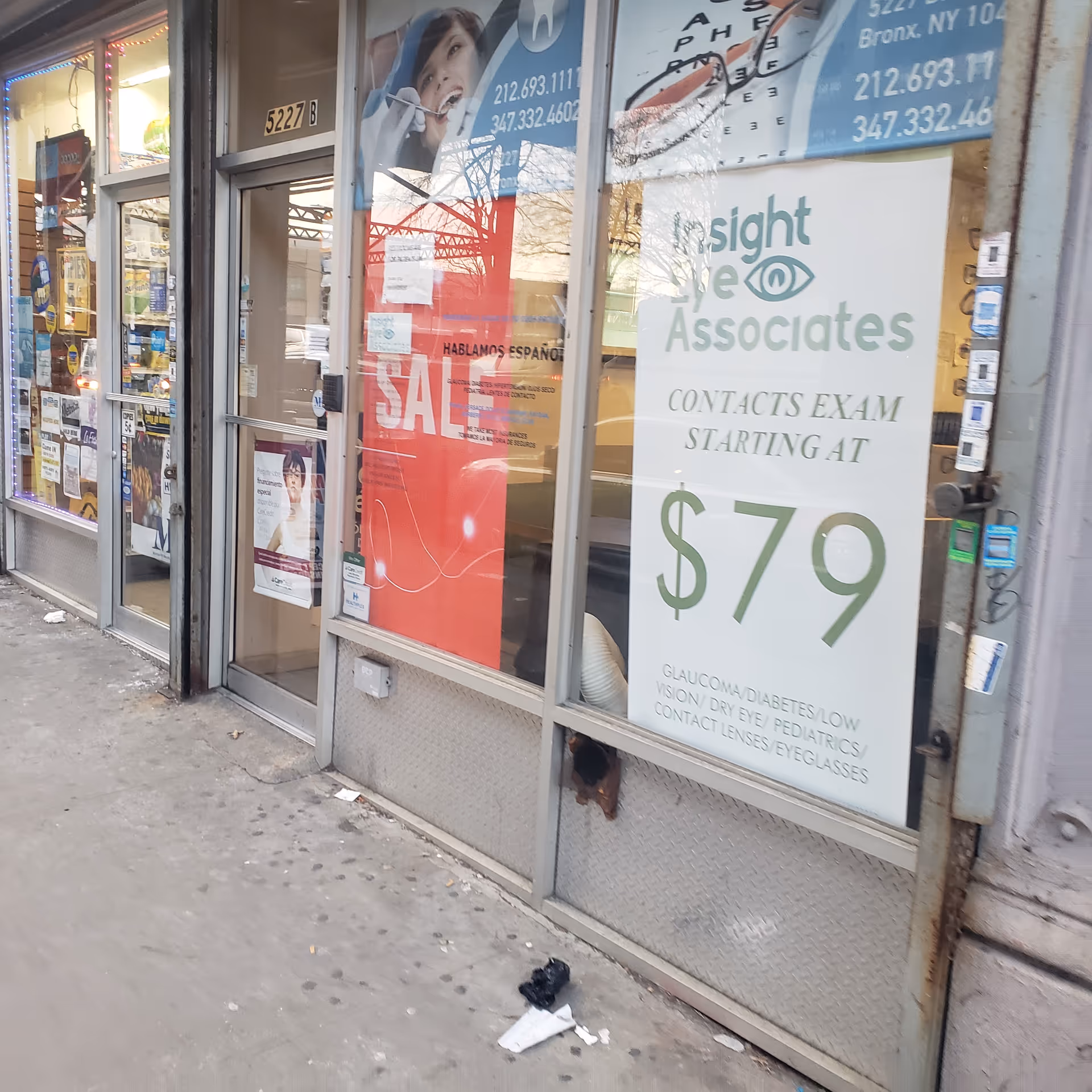 Exterior storefront with posters and a large sale sign in the window.