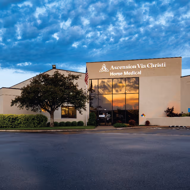 Front exterior of Ascension Via Christi Home Medical building with glass entrance and trees.
