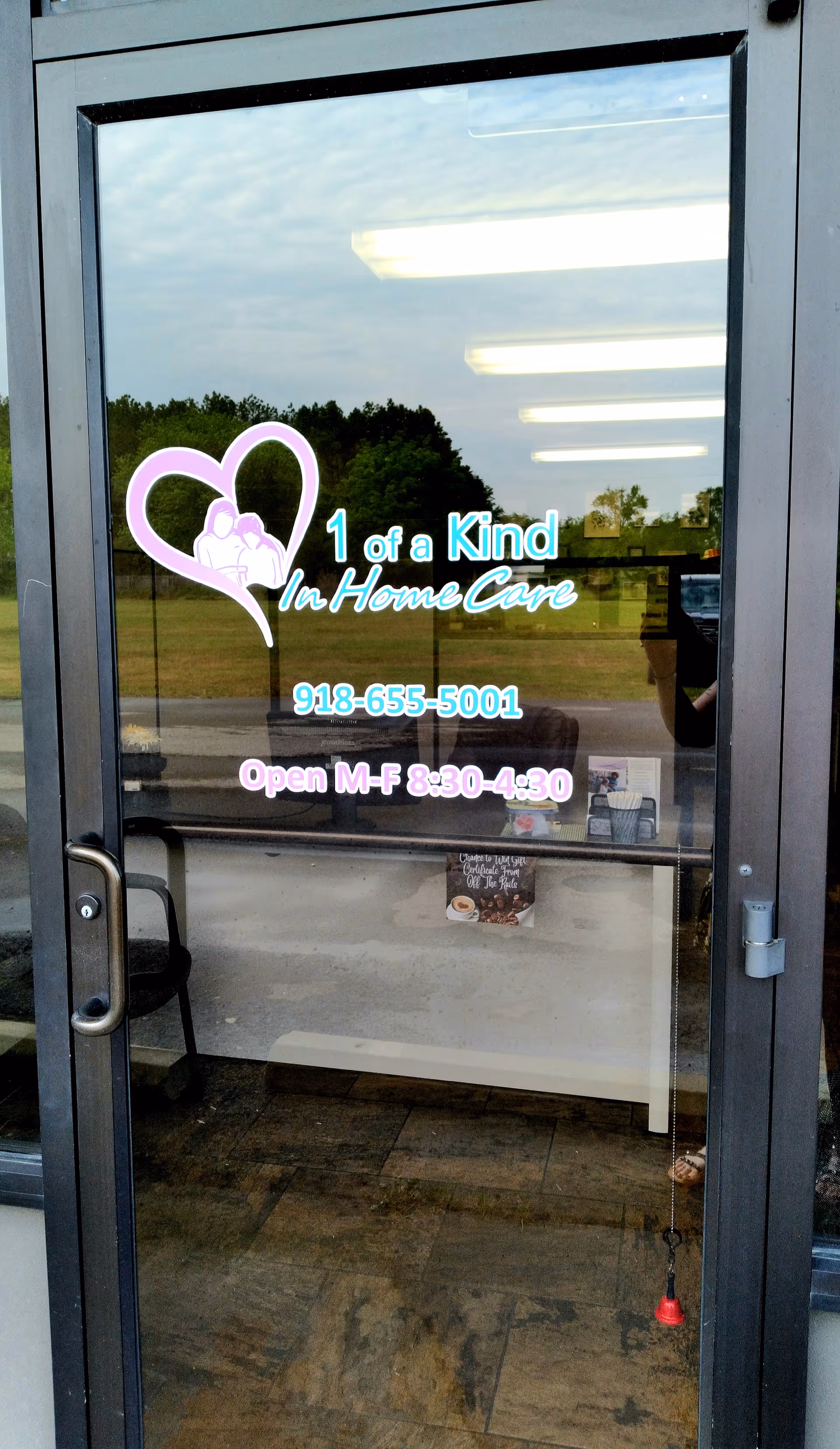 Glass entrance door for 1 of a Kind In Home Care with logo and hours.