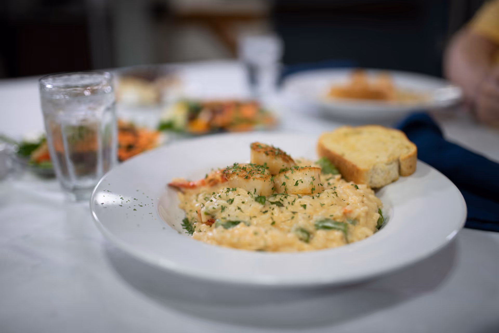 Creamy plated dish with croutons and bread slices on a dining table.