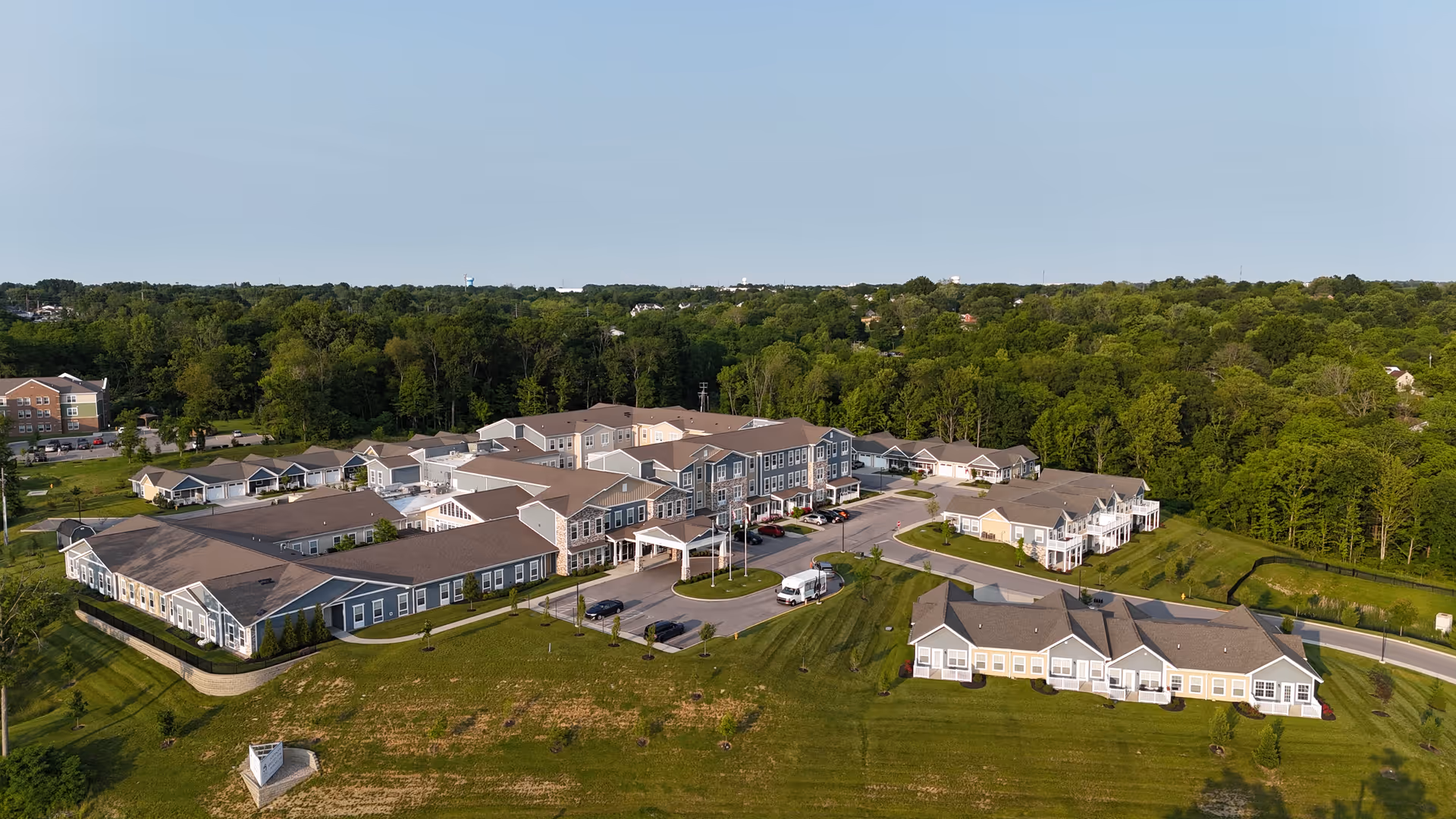 Aerial view of the Legacy Living Florence campus with connected buildings, parking, and expansive green lawns.