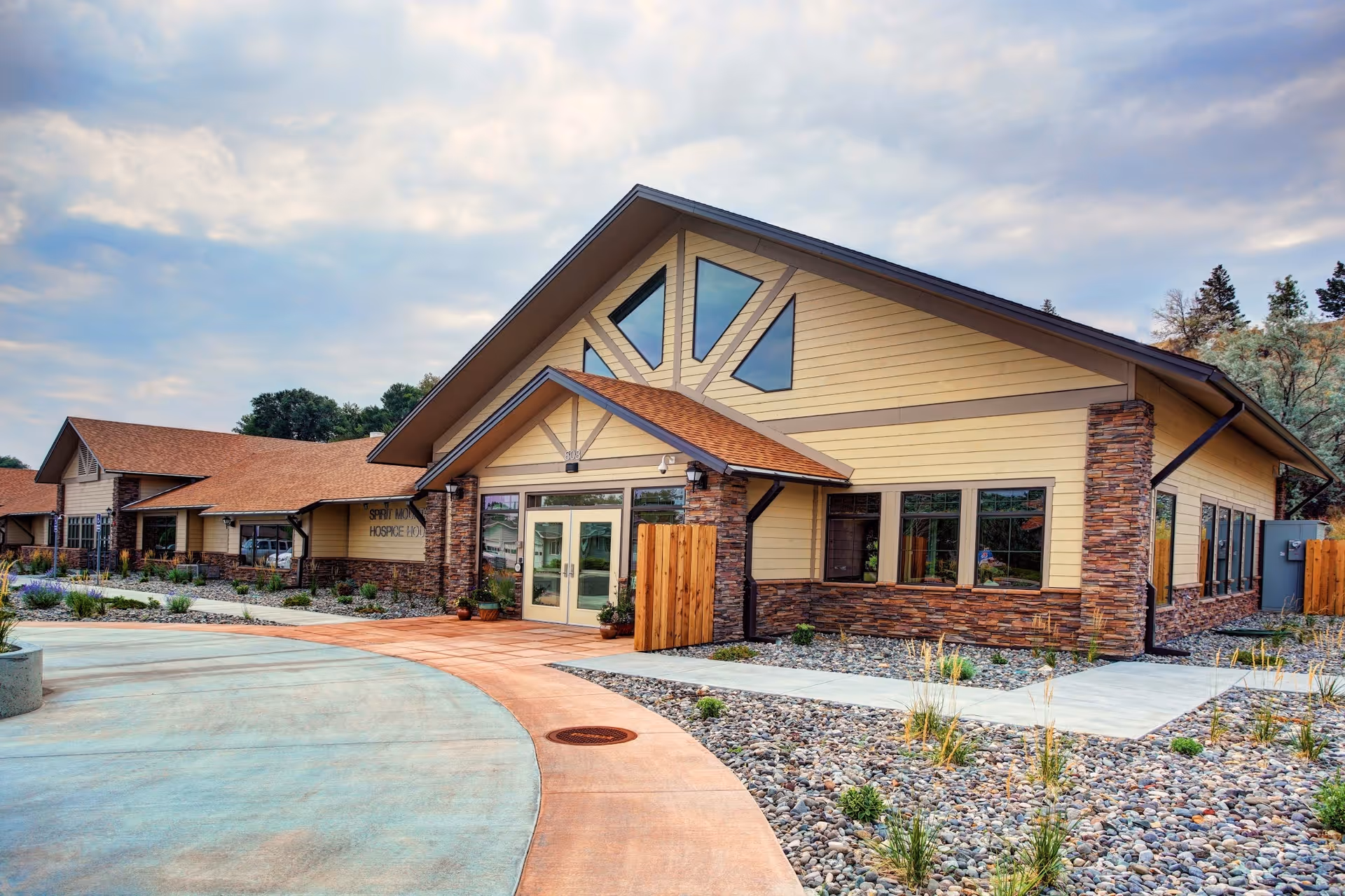 Exterior view of Cody Regional Health Spirit Mountain Hospice House with a curved walkway.