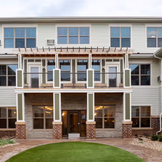 Two-story Aspire Senior Living Oshkosh exterior with a covered entrance and second-floor balcony.